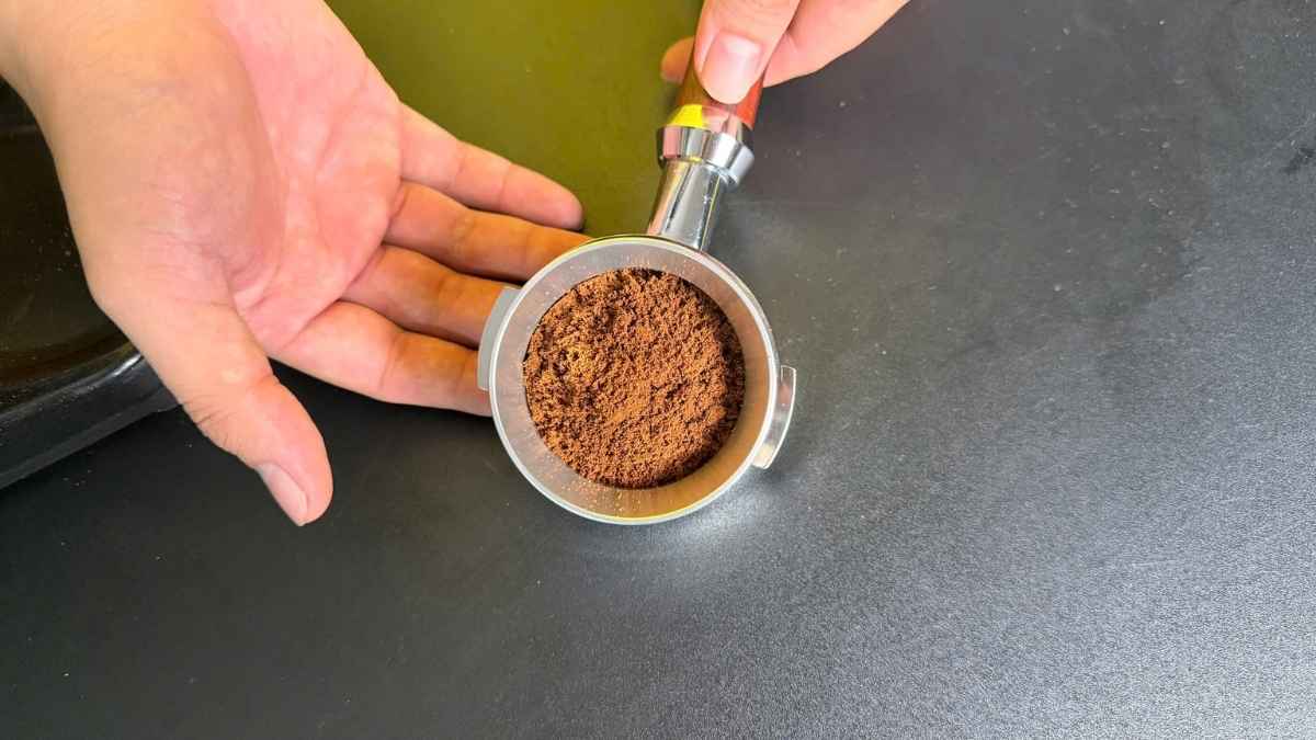 Barista sử dụng phễu nhôm 58mm để định lượng cà phê espresso chuẩn xác
