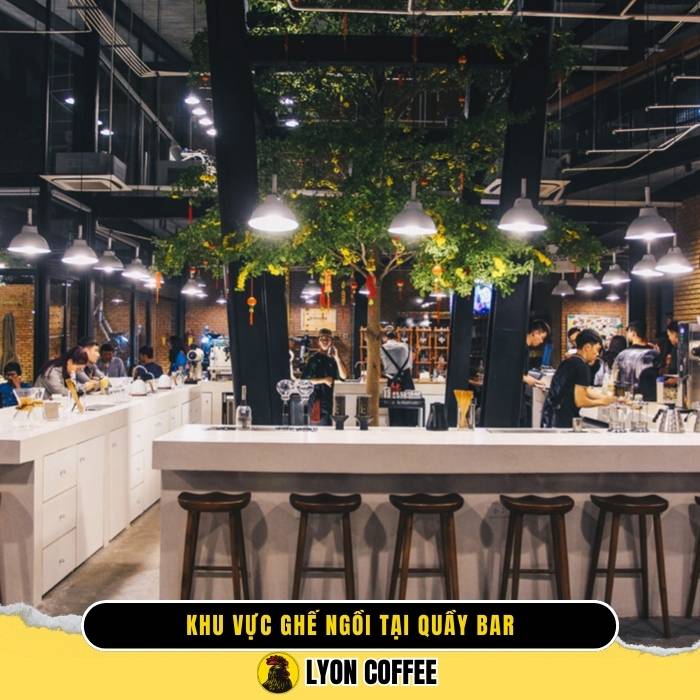 Quầy bar gọn gàng và ghế dài xung quanh cho phép khách hàng tương tác trực tiếp với barista