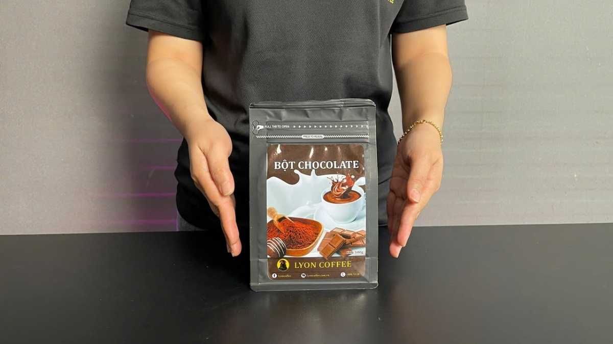 Túi zip bạc 500g ba lớp của Bột Chocolate Lyon Coffee đặt trên nền bàn bar