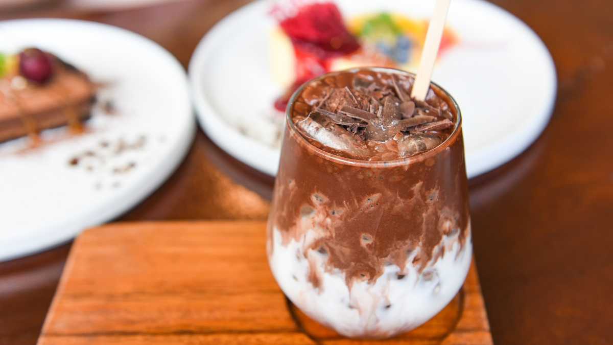 Ba ly đồ uống: socola đá xay, mocha latte và chocolate nóng trên nền gỗ quán