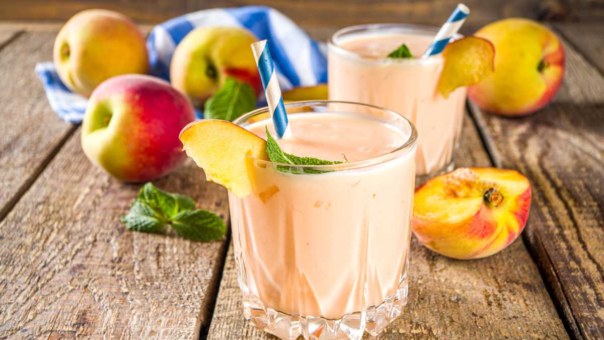 Ba ly trà đào, trà sữa đào và đá xay đào được bày cùng lát đào tươi