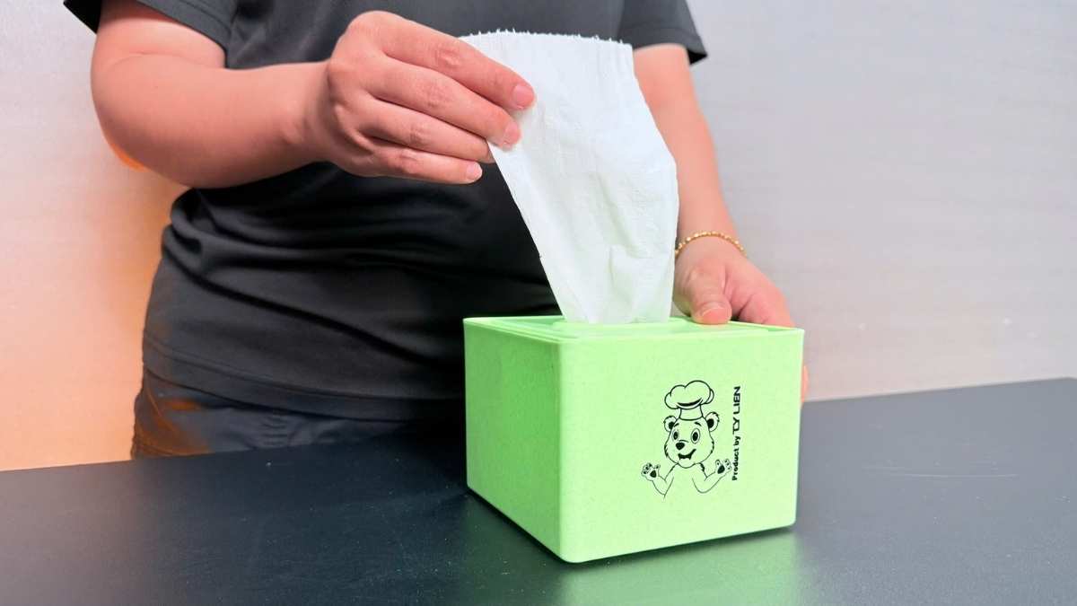 Khách hàng chọn hộp giấy ăn nhựa PP trên bàn cà phê.