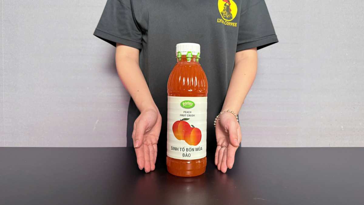 Ly trà đào Osterberg với lát đào thật và đá viên trong ly thủy tinh sáng màu