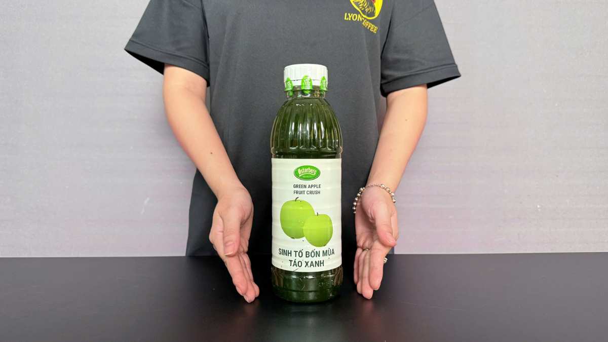 Ly trà táo xanh Osterberg với lát táo tươi và đá lạnh trên nền sáng