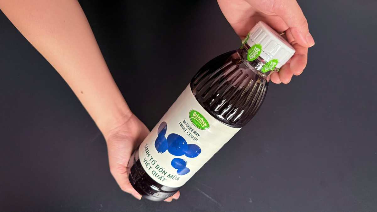 Logo Osterberg Đan Mạch cạnh chai sinh tố việt quất trên nền trắng sáng