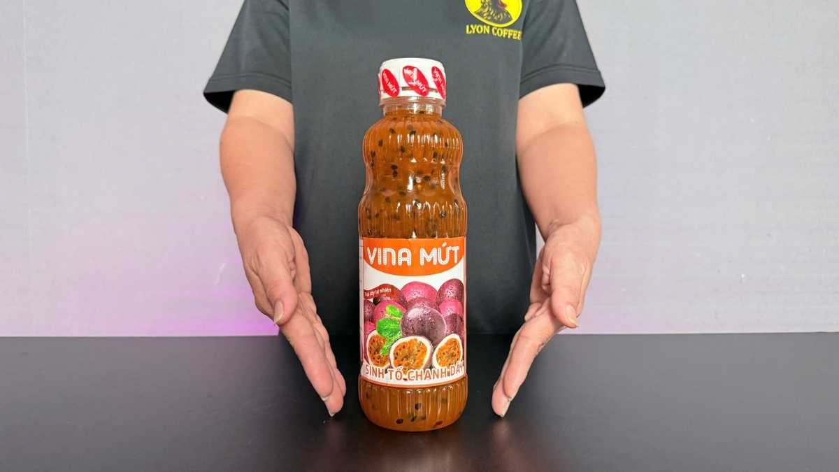 Chai Sinh Tố Vina Chanh Dây 1L đặt cạnh ly sinh tố chanh dây vàng cam và lát chanh tươi