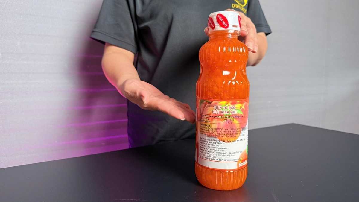 Ly sinh tố đào màu vàng cam, ánh sáng tự nhiên nhẹ, nền gỗ sáng