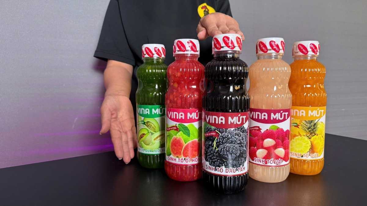 Logo Vina Mứt San Hô Xanh và chai Sinh Tố Dâu Tằm đặt nền sáng trắng