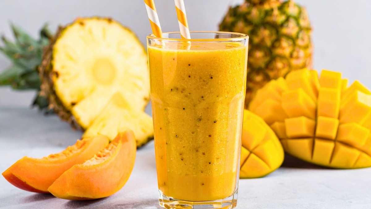 Ly trà dứa tươi mát với lát dứa và lá bạc hà, nền sáng rực rỡ