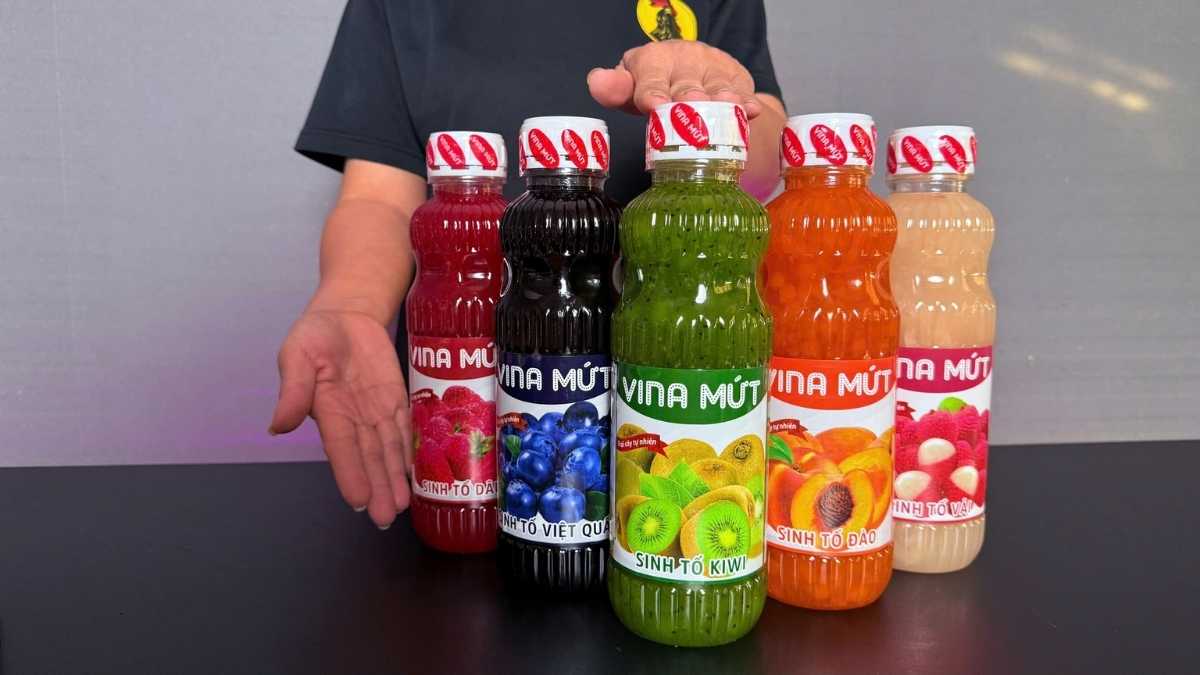 Logo Vina Mứt San Hô Xanh bên cạnh chai Sinh Tố Kiwi trên nền trắng