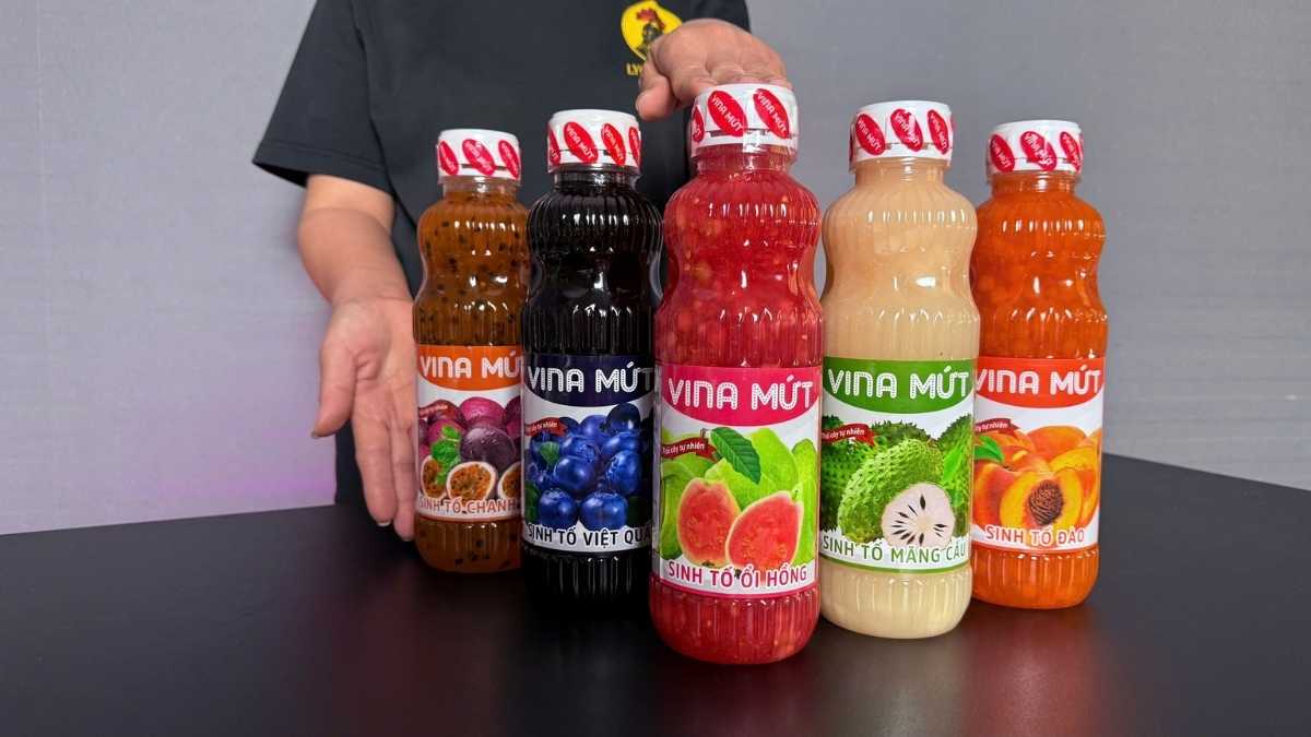 Logo Vina Mứt San Hô Xanh cạnh chai Sinh Tố Ổi Hồng trên nền trắng