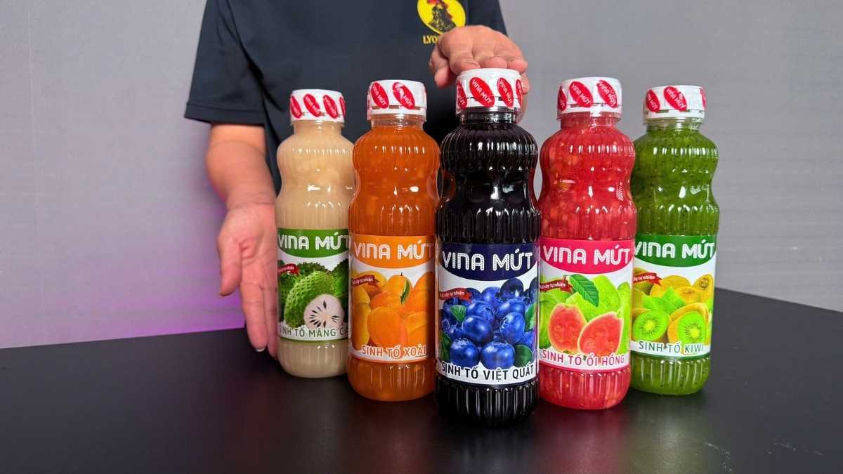 Logo Vina Mứt San Hô Xanh cạnh chai Sinh Tố Việt Quất trên nền trắng