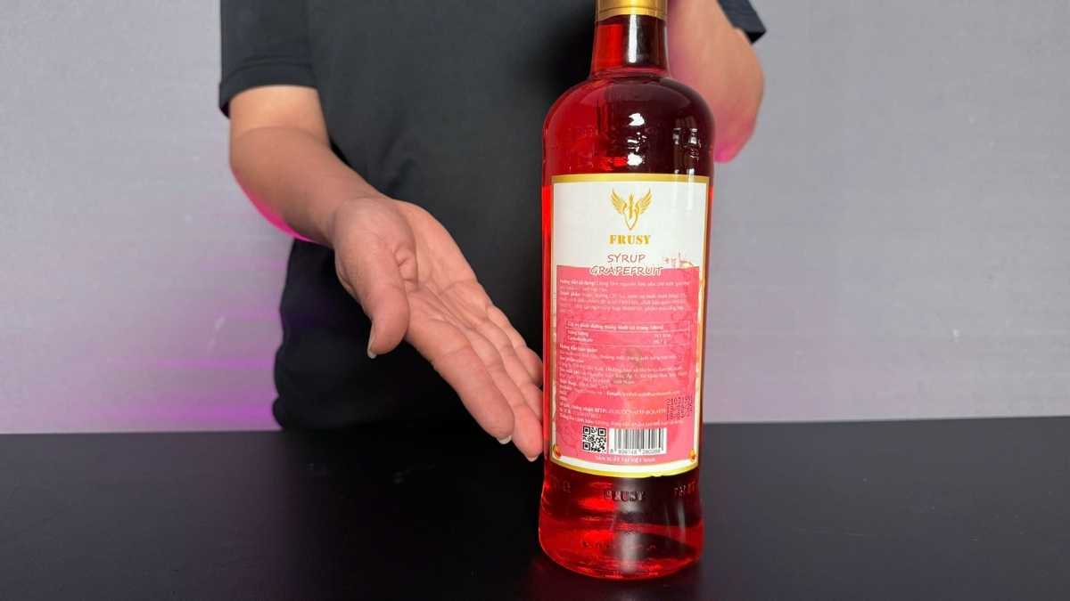 Ly syrup hồng trong cùng lát bưởi tươi và lá bạc hà trên nền sáng