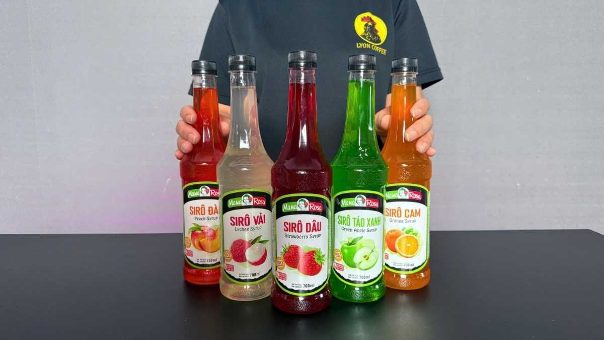 Barista sử dụng siro dâu để pha trà dâu cam sả và soda dâu