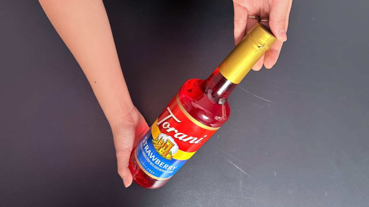 Logo Torani USA cạnh chai Siro Torani Dâu trên quầy bar sang trọng