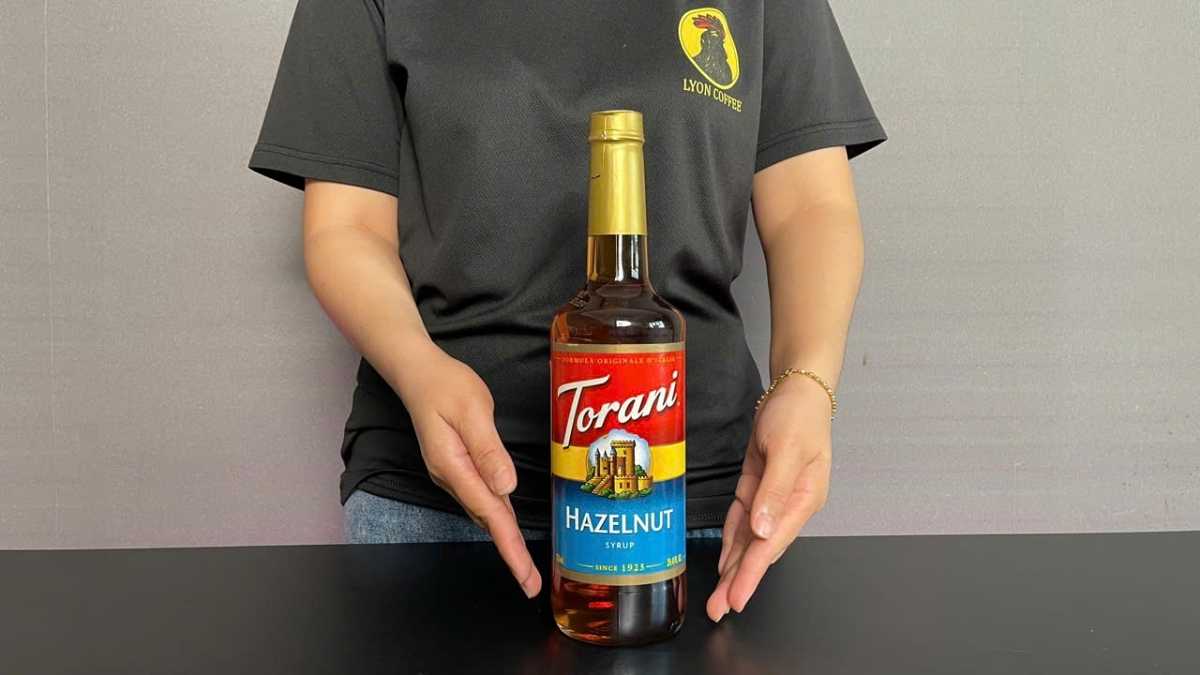 Ly latte hạt dẻ trên nền gỗ tối, hương thơm béo nhẹ lan tỏa