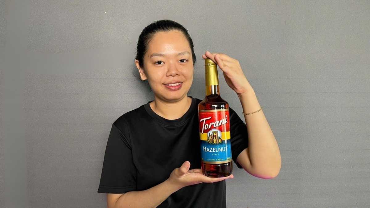 Chai Siro Torani Hạt Dẻ 750ml đặt cạnh ly latte hạt dẻ màu kem nâu ấm