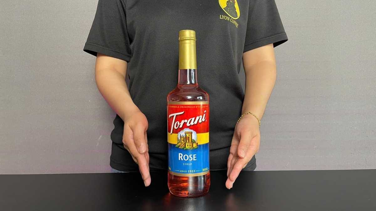 Ly trà hoa hồng trong suốt, vài cánh hoa tươi trang trí nhẹ nhàng