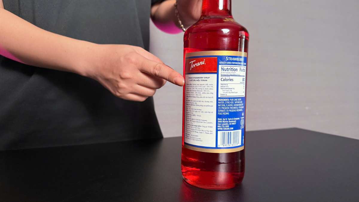 Cận cảnh giọt Siro Torani Dâu rơi vào ly nước trong ánh sáng tự nhiên