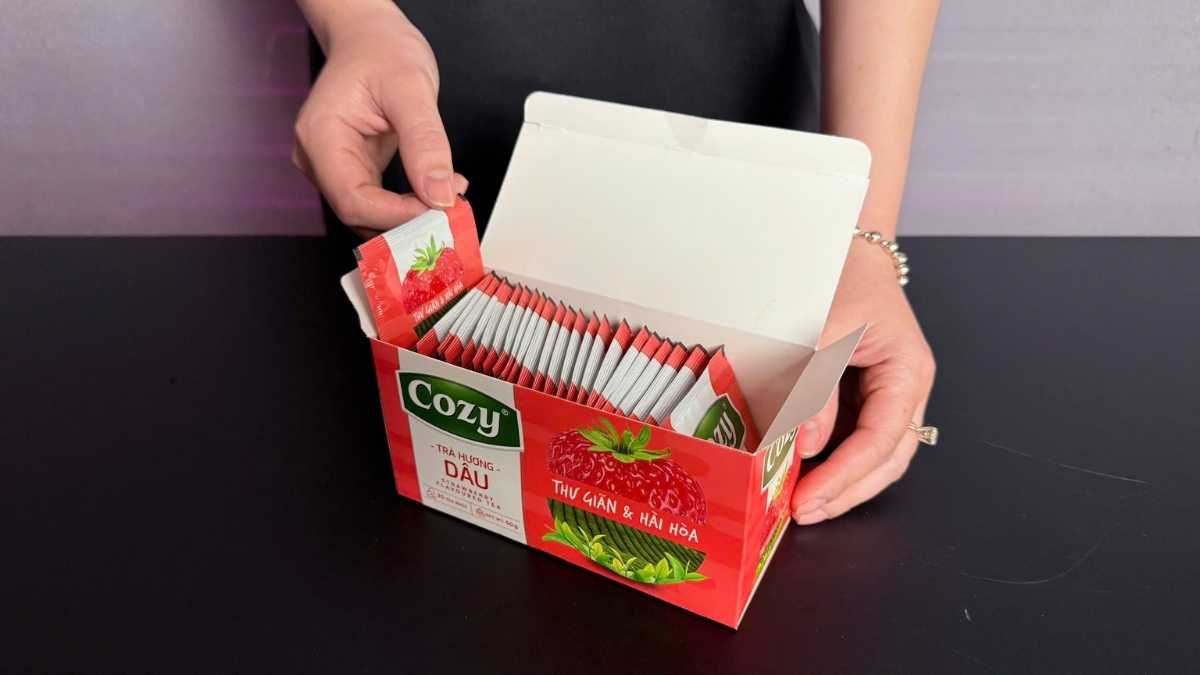 Hộp Trà Cozy Hương Dâu 50g gồm 25 túi lọc nhỏ, nền hồng đỏ tươi, thương hiệu Cozy Việt Nam