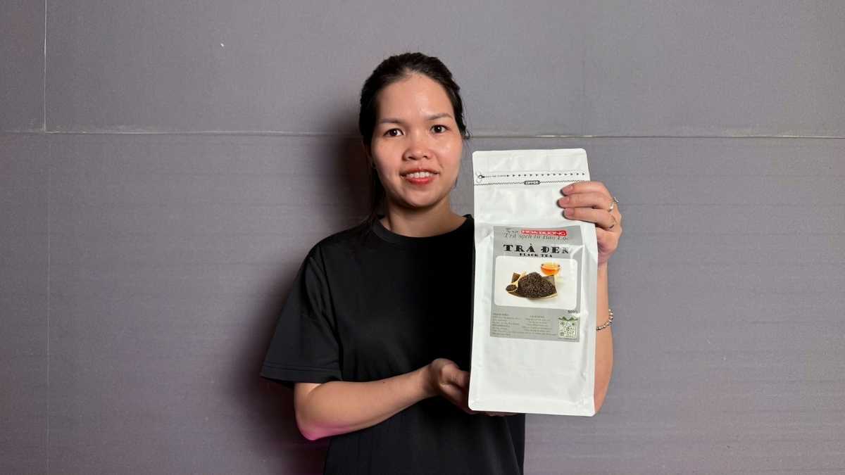 Túi Trà Đen Hoa Dương 500g đặt cạnh tách trà hổ phách và ấm trà thủ công