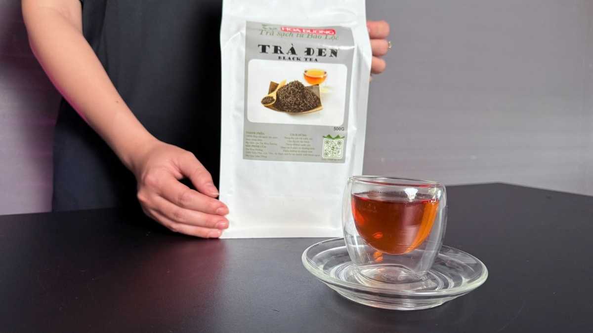 Túi trà bạc ép kín 500g đặt trên nền bàn gỗ, bên cạnh ấm pha trà