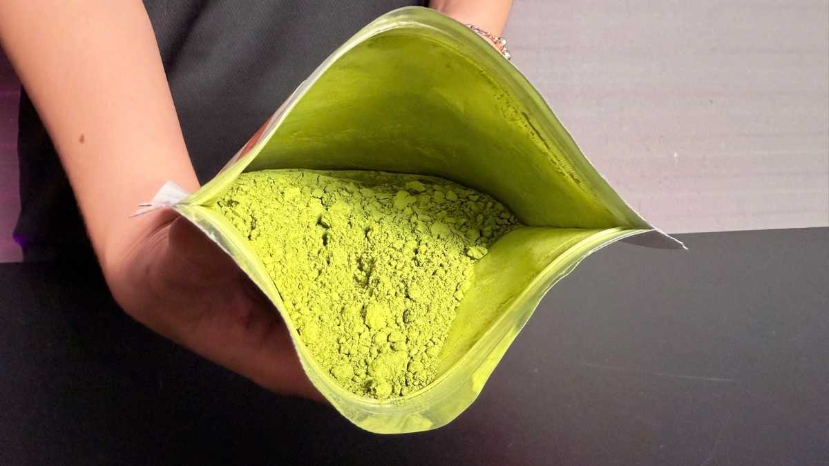 Ly matcha latte hoa nhài tươi mát, nền gỗ sáng, đặt cạnh bông hoa nhài