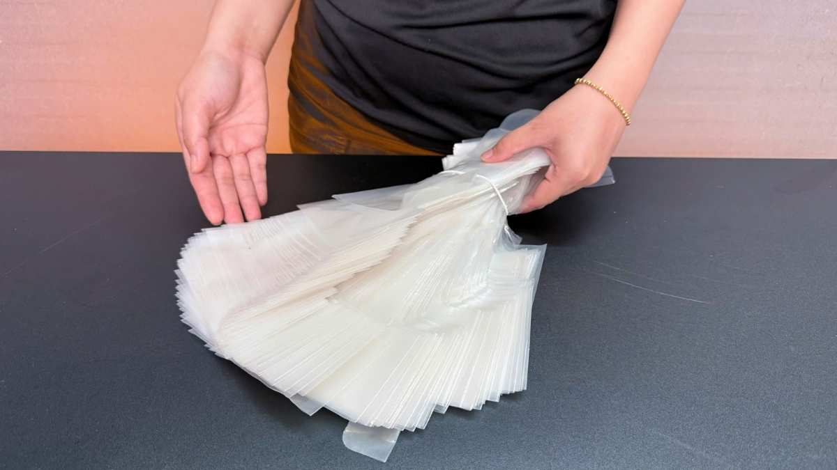 Nhân viên văn phòng cầm túi chữ T mang nhiều ly cà phê đi họp.